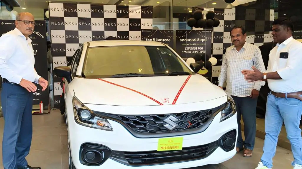 our-member-with-a-new-white-maruti-suzuki-baleno-at-a-car-dealership |Vishwa Mangal Motor Driving School